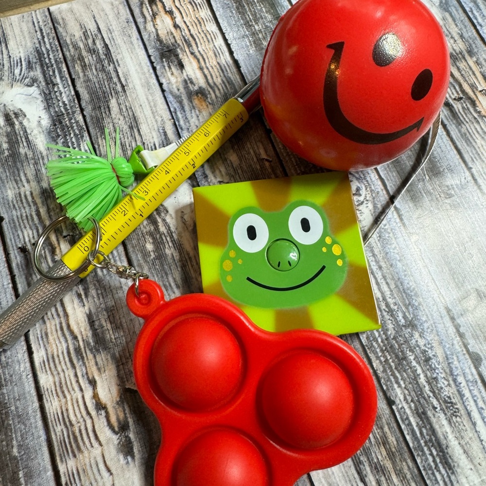 4 piece set of a stress ball, popper, multi use pen, a frog measuring tape.